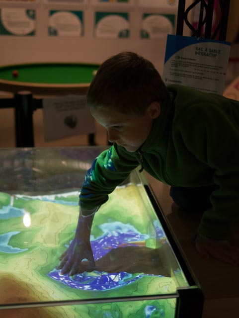 Making virtual lakes by digging in the Augmented Reality Sandbox exhibit at the Exploradome.