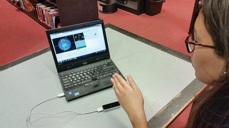 The gesture input device, the Leap Motion controller, senses the angle the student's hand makes with the tabletop.