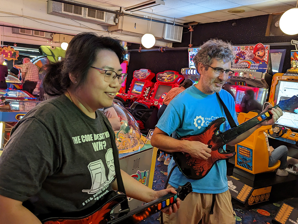 Two people playing Rock Band at local arcade