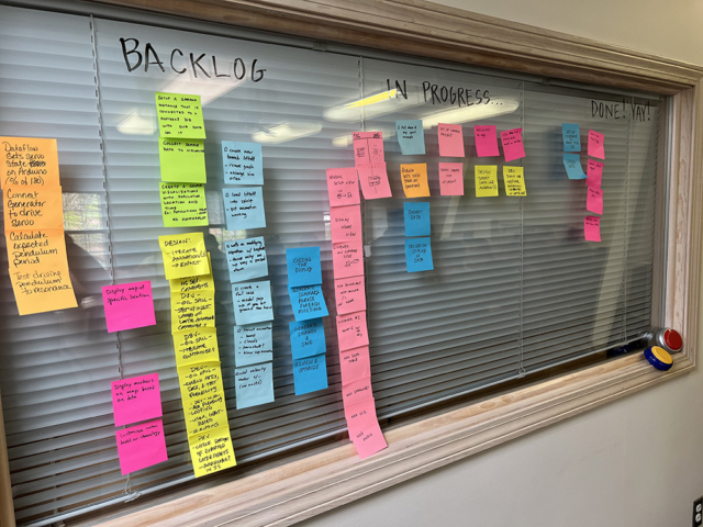 Wall of Post-it notes with development stories